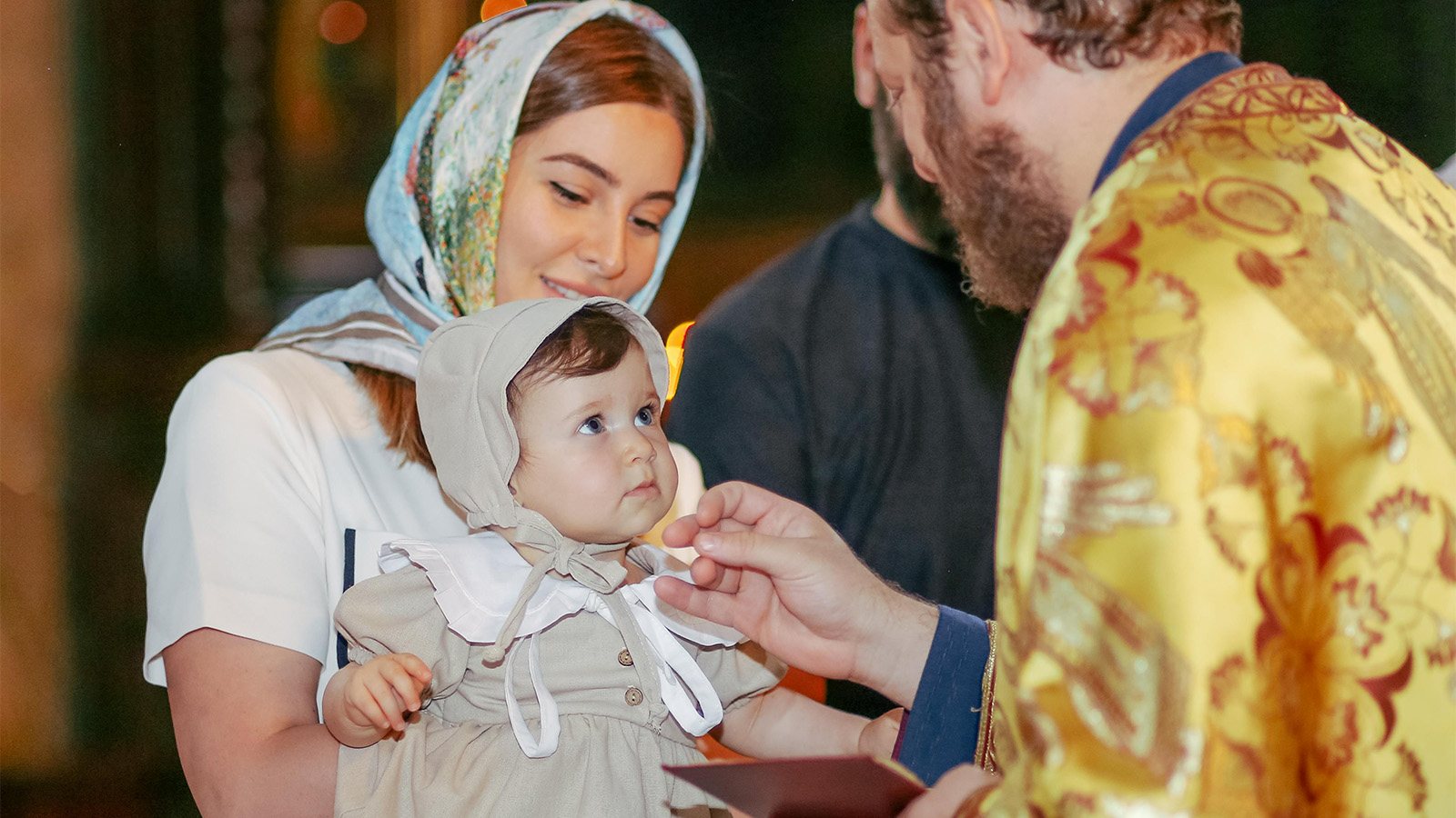 Mother and child with priest in an orthodox church 