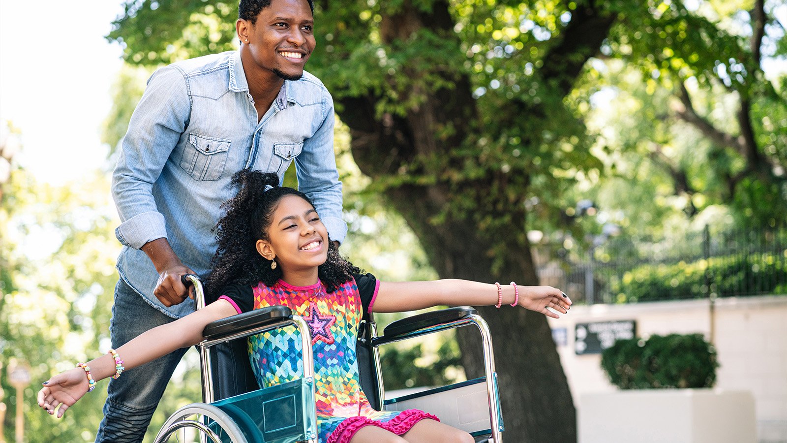 Father pushing child in a wheelchair