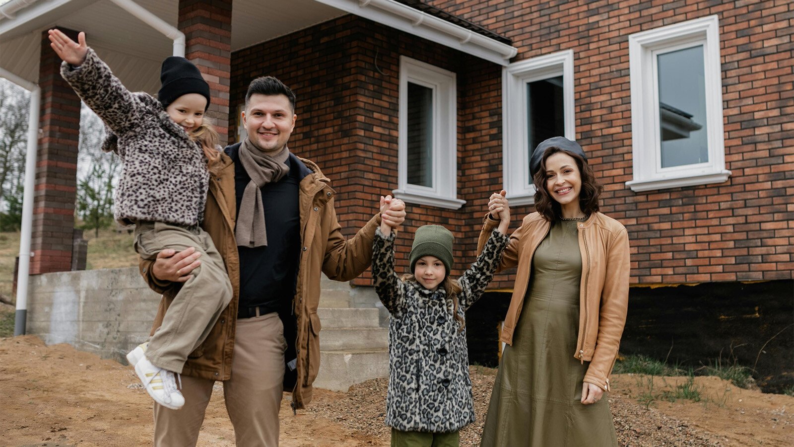 Family standing in front of their new home 