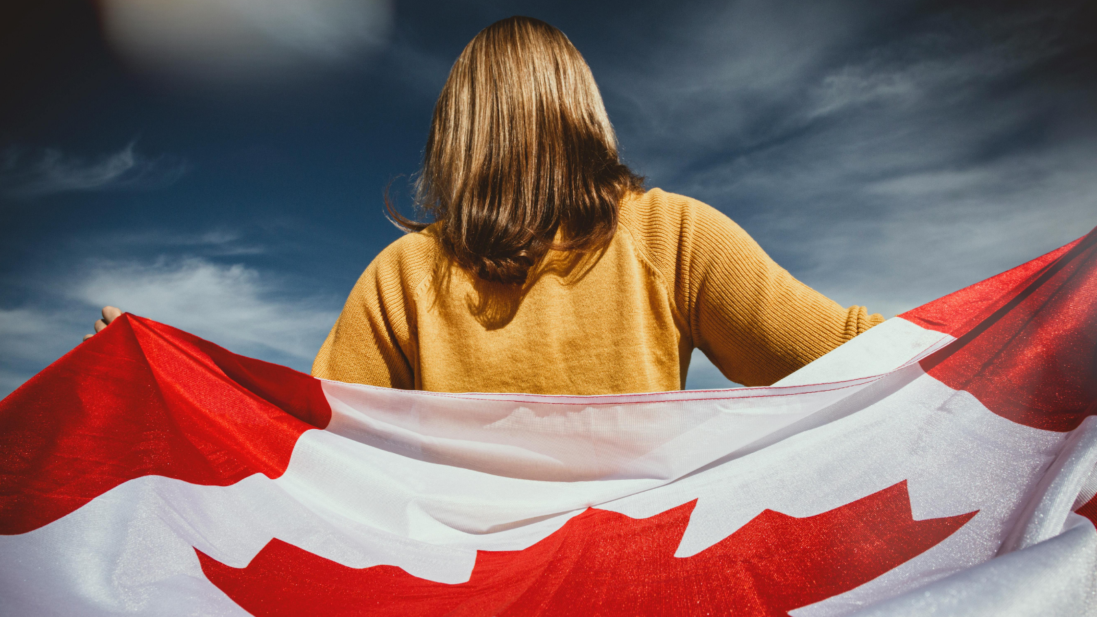 Back of woman holding Canadian flag
