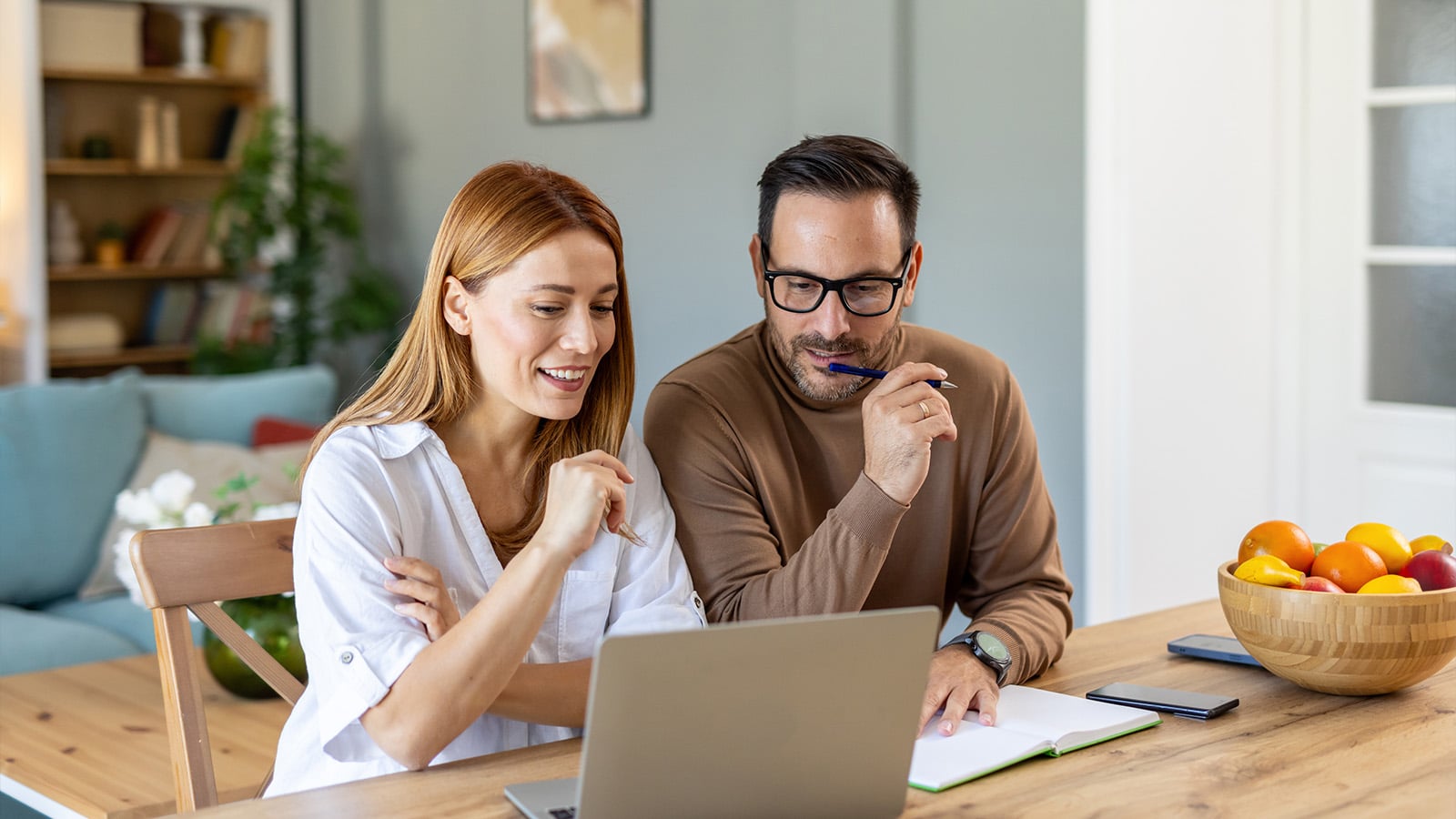 Couple in their thirties, managing finances on a laptop 