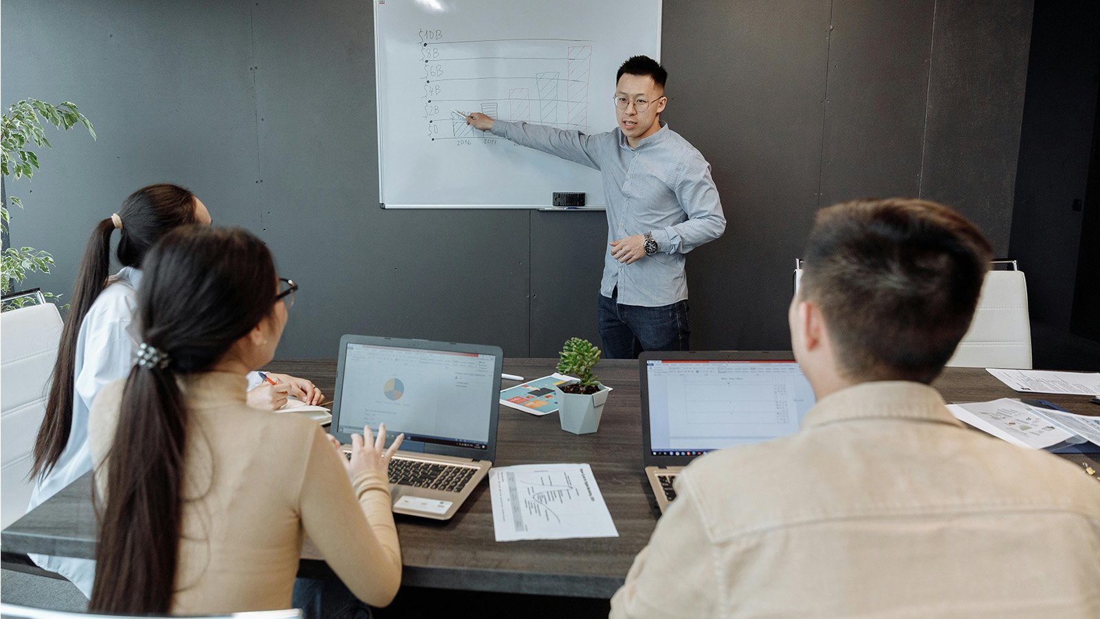Man explaining economics to a small classroom 
