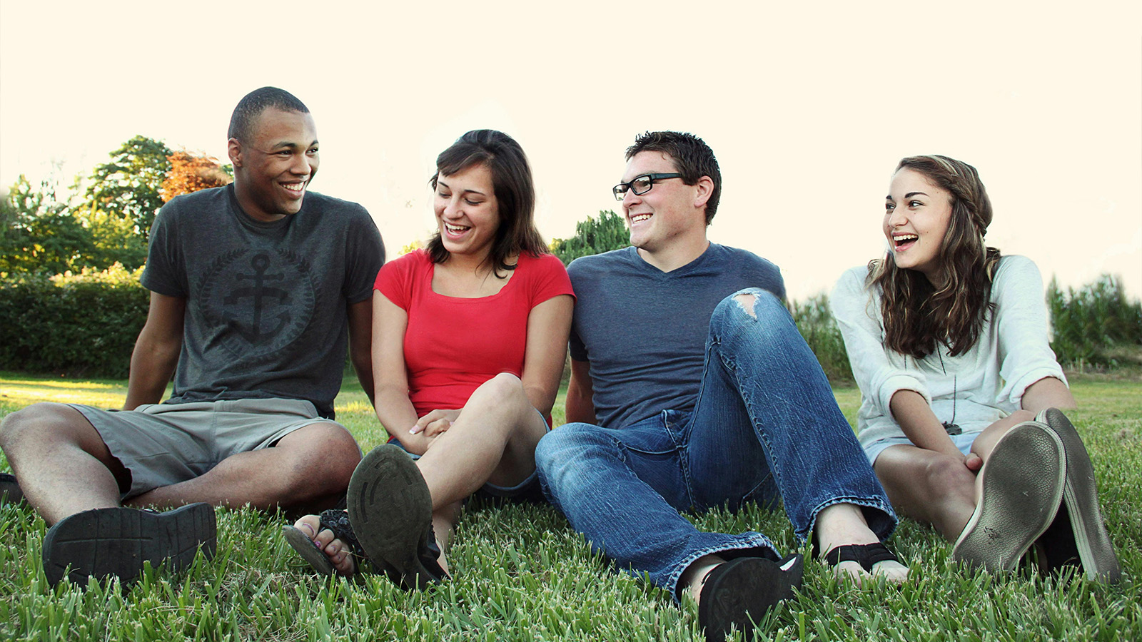 Young adults sitting in the grass 